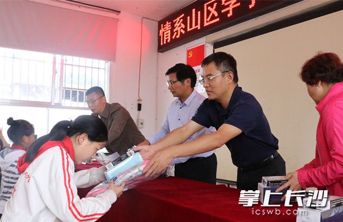 乐竞·体育博士团队向龙山学生赠送书本。长沙晚报通讯员朱珊供图